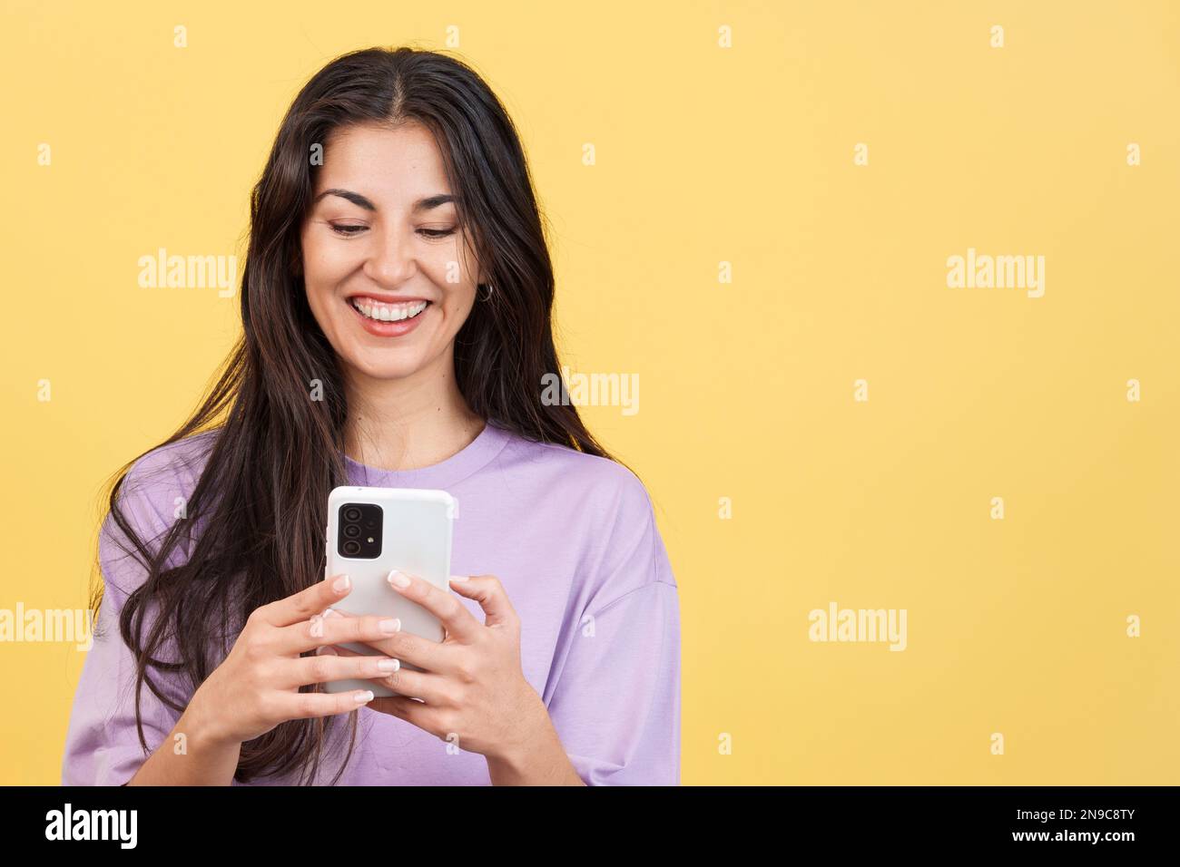 Felice donna caucasica sorridente mentre si utilizza il cellulare Foto Stock