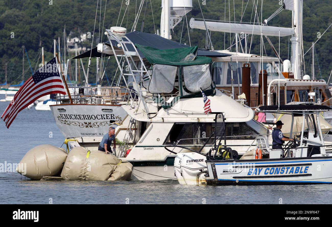 A police vessel tows into a marina a yacht, center, that capsized and ...