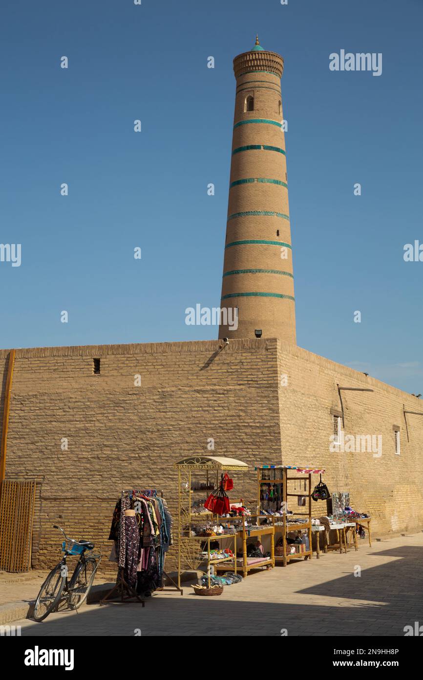 Beni turistici in vendita (primo piano), Juma Minareto (sfondo), Ichon Qala, Khiva, Uzbekistan Foto Stock