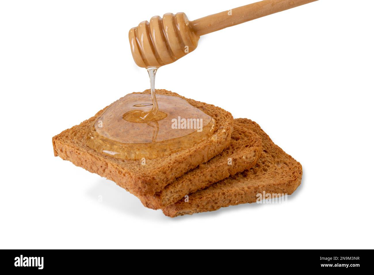 Miele d'acacia che sgocciola dal cucchiaiato di miele sulle fette di pane tostato, isolato su bianco, percorso di taglio Foto Stock