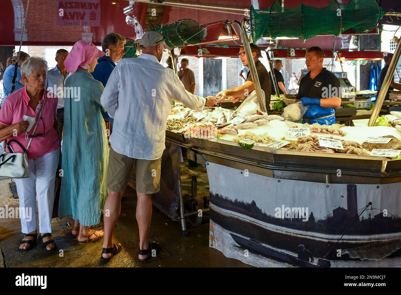Le persone che acquistano il pescato del giorno sotto la Loggia del mercato ittico nel sestiere di San Polo, Rialto mercato, Venezia, Veneto, Italia Foto Stock