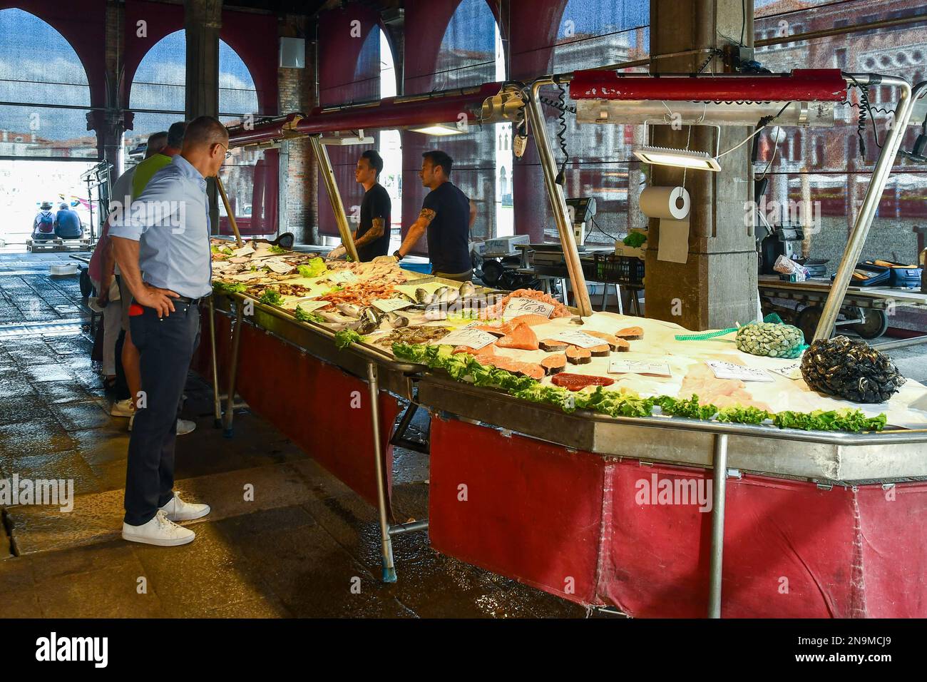 Le persone che acquistano il pescato del giorno sotto la Loggia del mercato ittico nel sestiere di San Polo, Rialto mercato, Venezia, Veneto, Italia Foto Stock