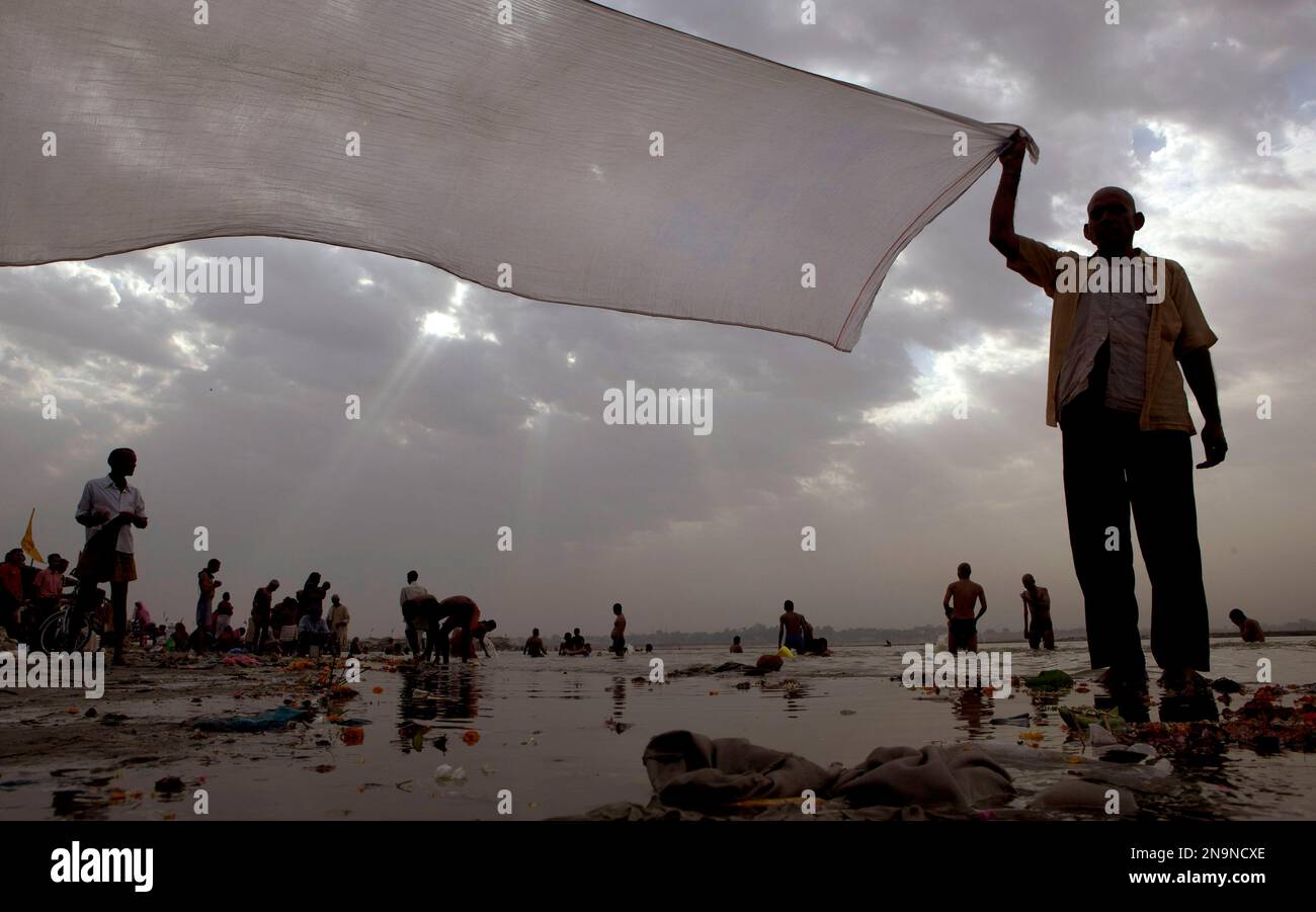 Hindu devotees take ritualistic dips in the River Ganges at Sangam, the confluence of the Rivers Ganges, Yamuna and the mythical Saraswati, in Allahabad, India, Tuesday, June 5, 2012. Hindus across the country worship the River Ganges, considered as the most sacred and the holiest river. The water of the Ganges is worshiped in sealed containers in every home, sprinkled as a benediction of peace, and even as the last sacrament. (AP Photo/Rajesh Kumar Singh) Foto Stock