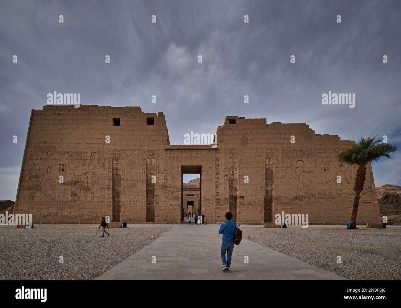 Tempio mortuario di Ramesse III a Medinet Habu a Luxor, Egitto vista luce del giorno esterna che mostra il primo pilone e l'ingresso principale al piazzale Foto Stock