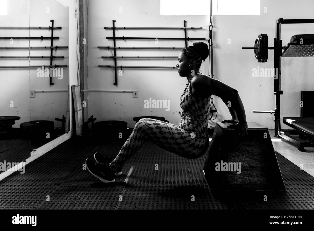 Donna determinata che fa le esercitazioni del braccio alla palestra. Rinforzo della carrozzeria. Foto Stock