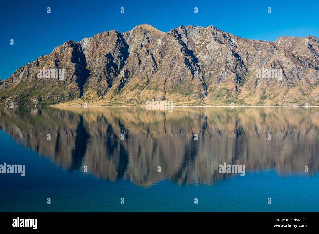 Acque calme e riflettenti del lago Hawea vicino a Wanaka, nuova Zelanda; regione di Otago, Isola del Sud, nuova Zelanda Foto Stock