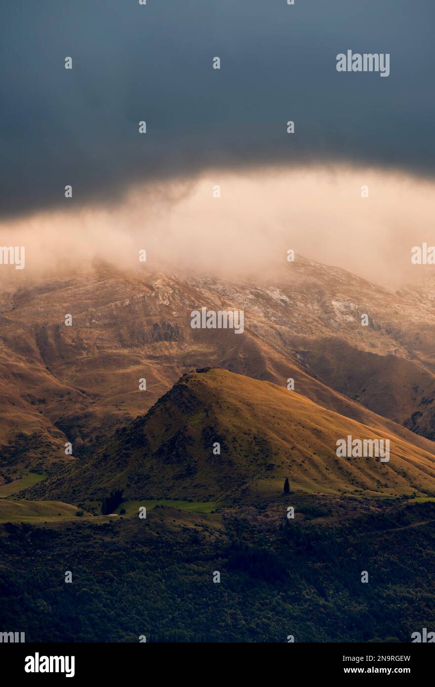 La luce dell'alba splende sulla valle di Cardrona nella regione di Otago in nuova Zelanda; South Island, nuova Zelanda Foto Stock