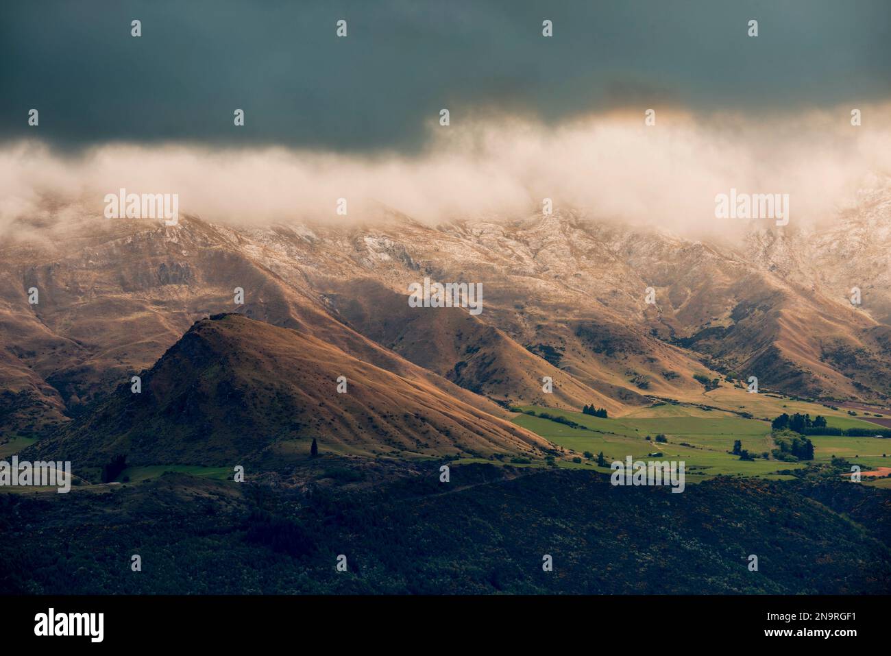 La luce dell'alba splende sulla valle di Cardrona nella regione di Otago in nuova Zelanda; South Island, nuova Zelanda Foto Stock