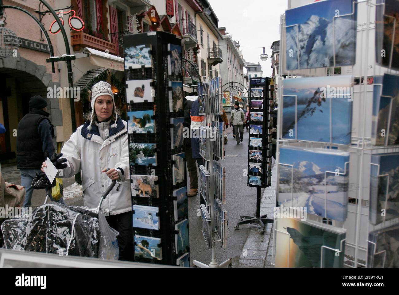 Donna che visita un negozio di cartoline turistiche che raffigurano il paesaggio alpino delle Alpi e le attrazioni presso uno stand laterale della strada che serve i turisti a Cham... Foto Stock