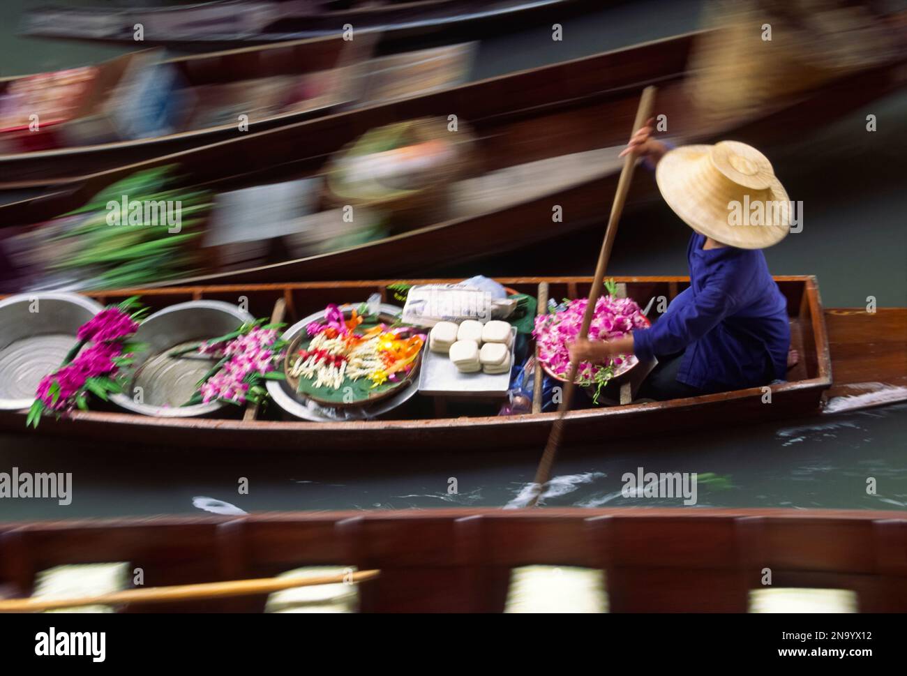 Venditore di fiori e altri beni al mercato galleggiante di Bangkok; Bangkok, Thailandia Foto Stock