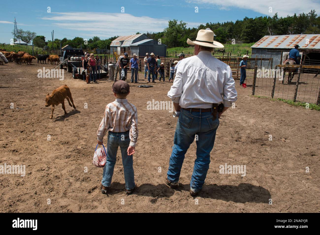 Un ragazzo di età elementare e un uomo di mezza età si trovano in un ranch; Burwell, Nebraska, Stati Uniti d'America Foto Stock