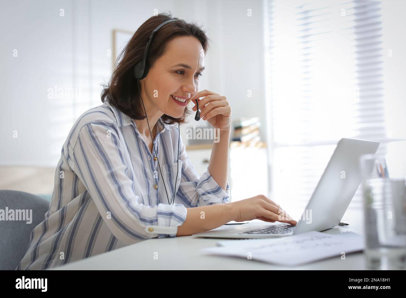 Insegnante che conduce una lezione online a casa durante la quarantena COVID-19 Foto Stock