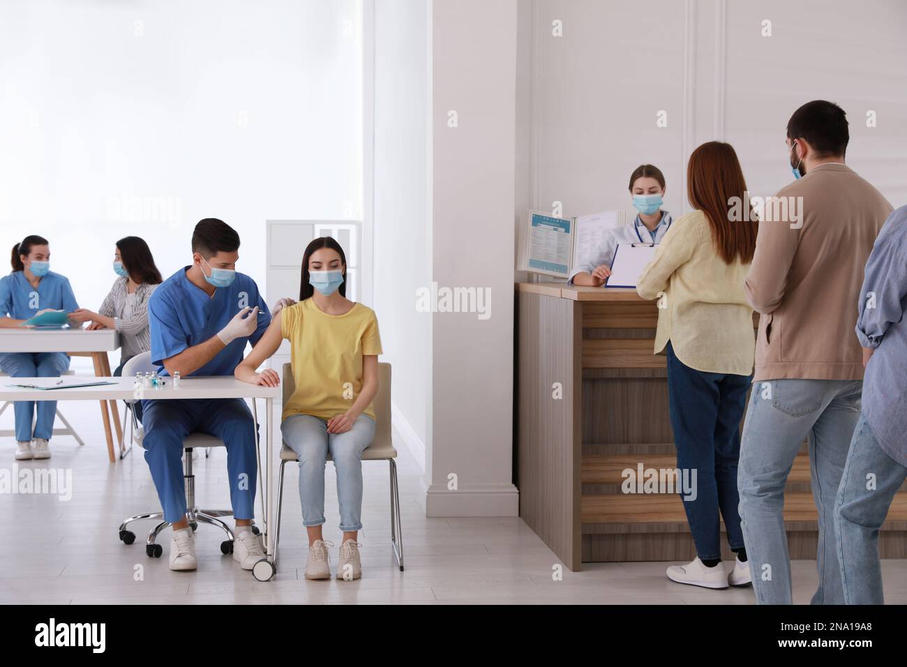 Persone in attesa di vaccinazione in coda in ospedale Foto Stock
