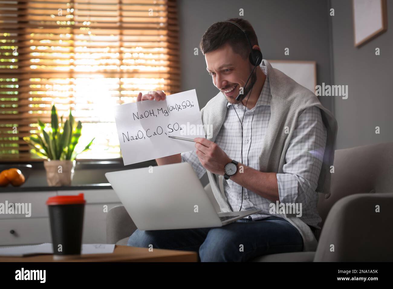 Insegnante che conduce una lezione online a casa durante la quarantena COVID-19 Foto Stock