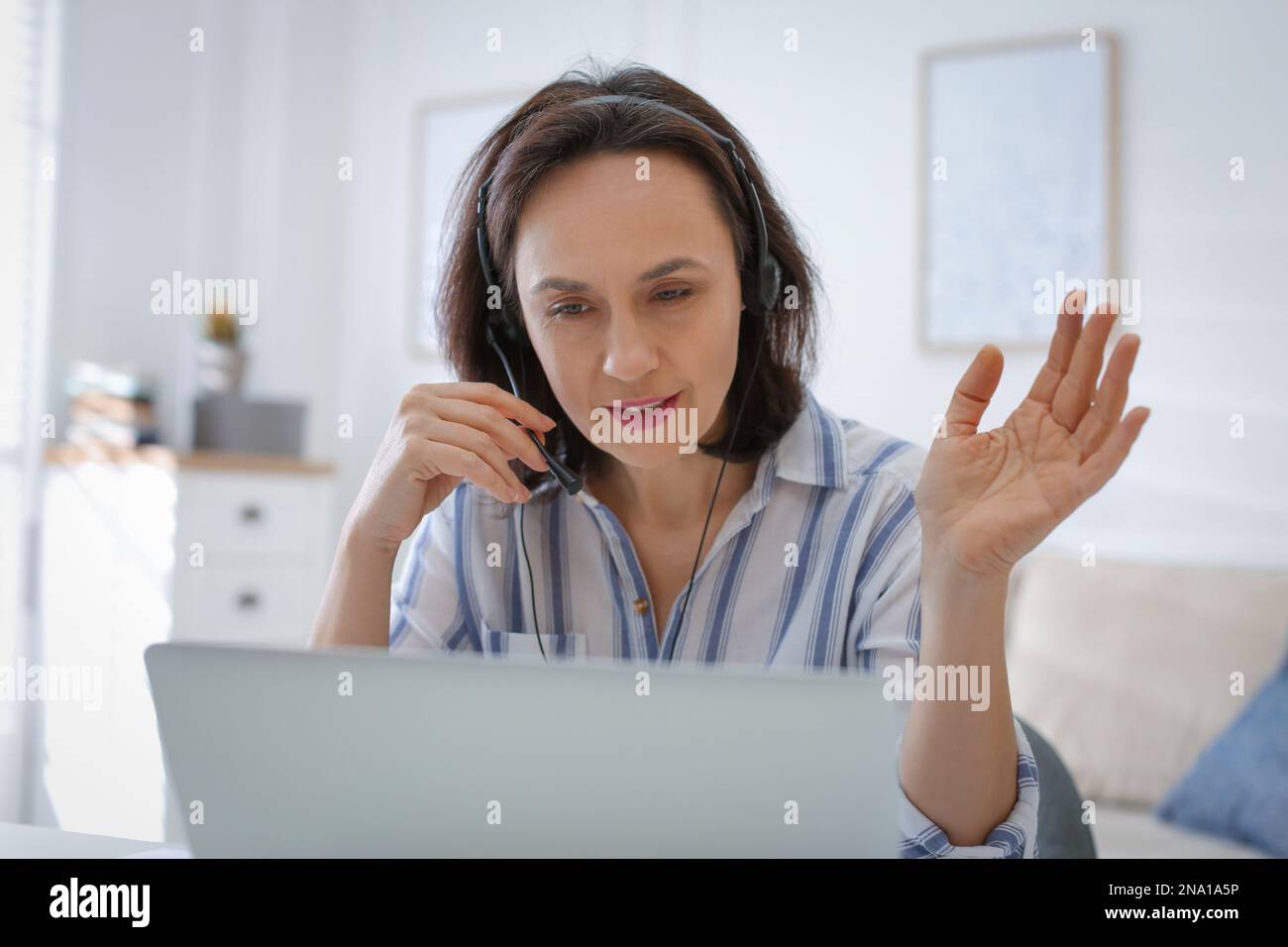 Insegnante che conduce una lezione online a casa durante la quarantena COVID-19 Foto Stock