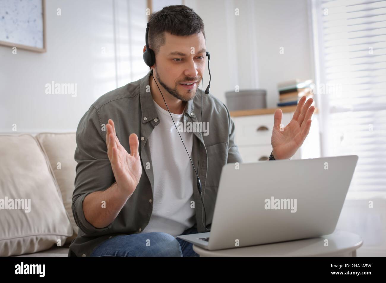 Insegnante che conduce una lezione online a casa durante la quarantena COVID-19 Foto Stock