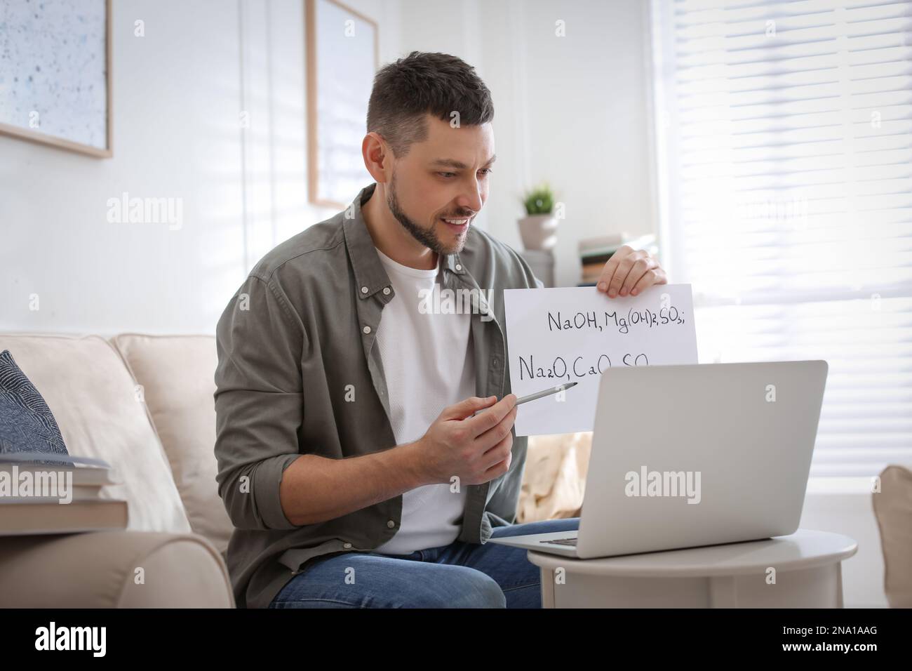 Insegnante che conduce una lezione online a casa durante la quarantena COVID-19 Foto Stock