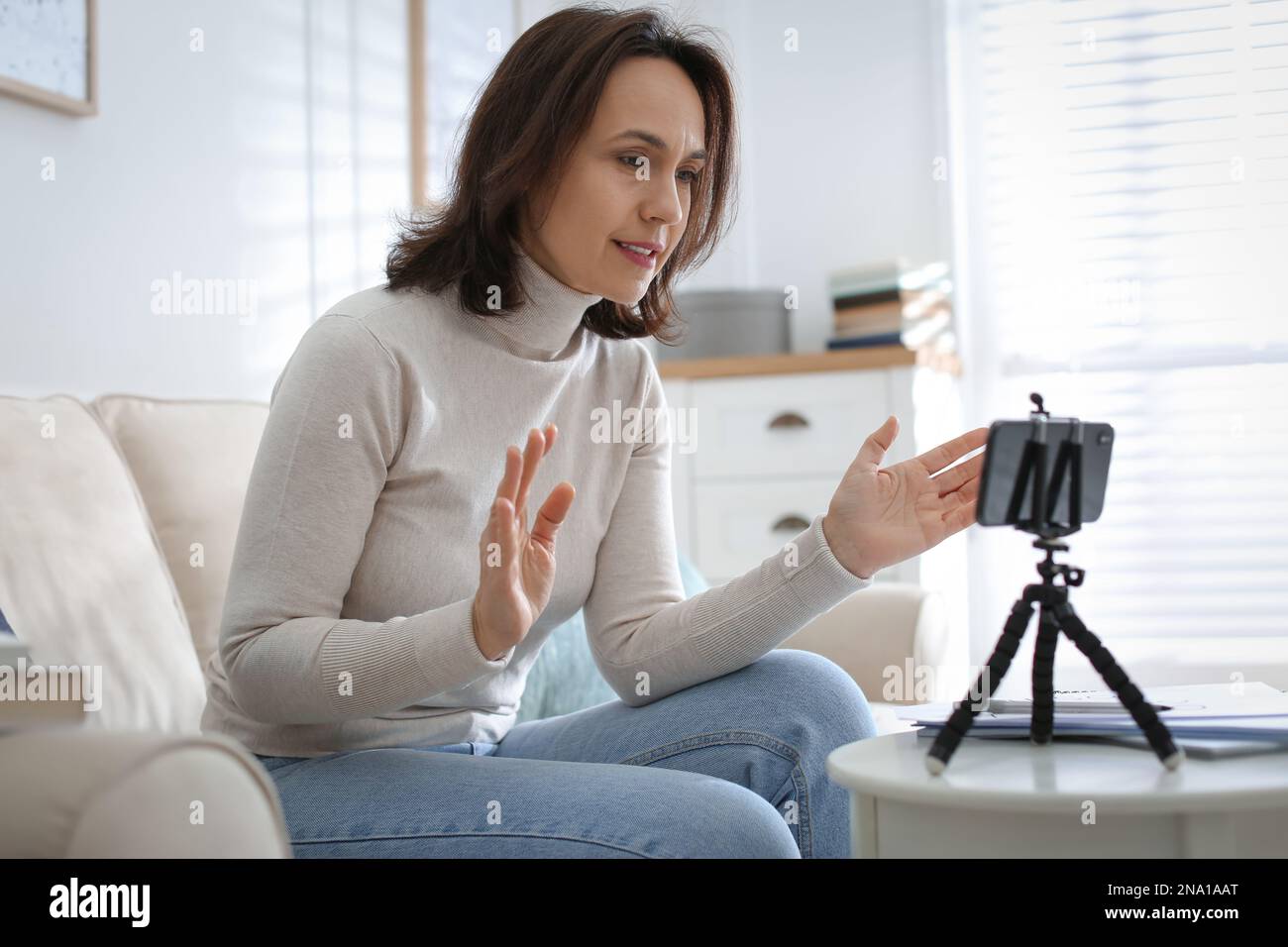 Insegnante che conduce una lezione online a casa durante la quarantena COVID-19 Foto Stock