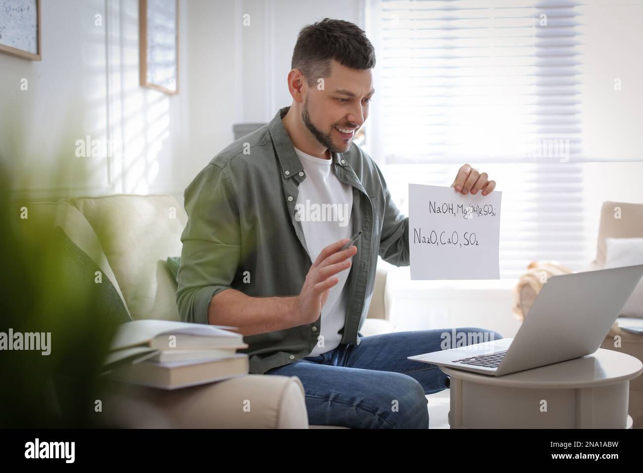 Insegnante che conduce una lezione online a casa durante la quarantena COVID-19 Foto Stock