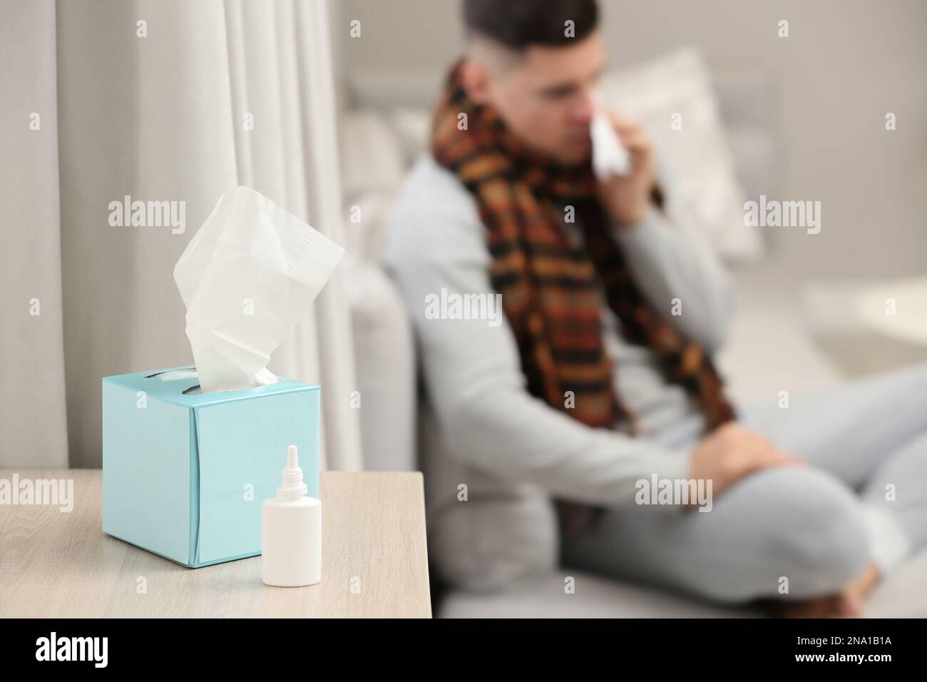 Malato uomo a casa, concentrarsi su spray nasale e scatola di tessuti Foto Stock