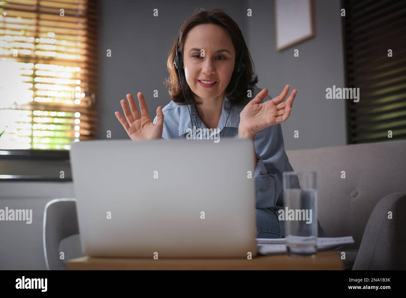 Insegnante che conduce una lezione online a casa durante la quarantena COVID-19 Foto Stock