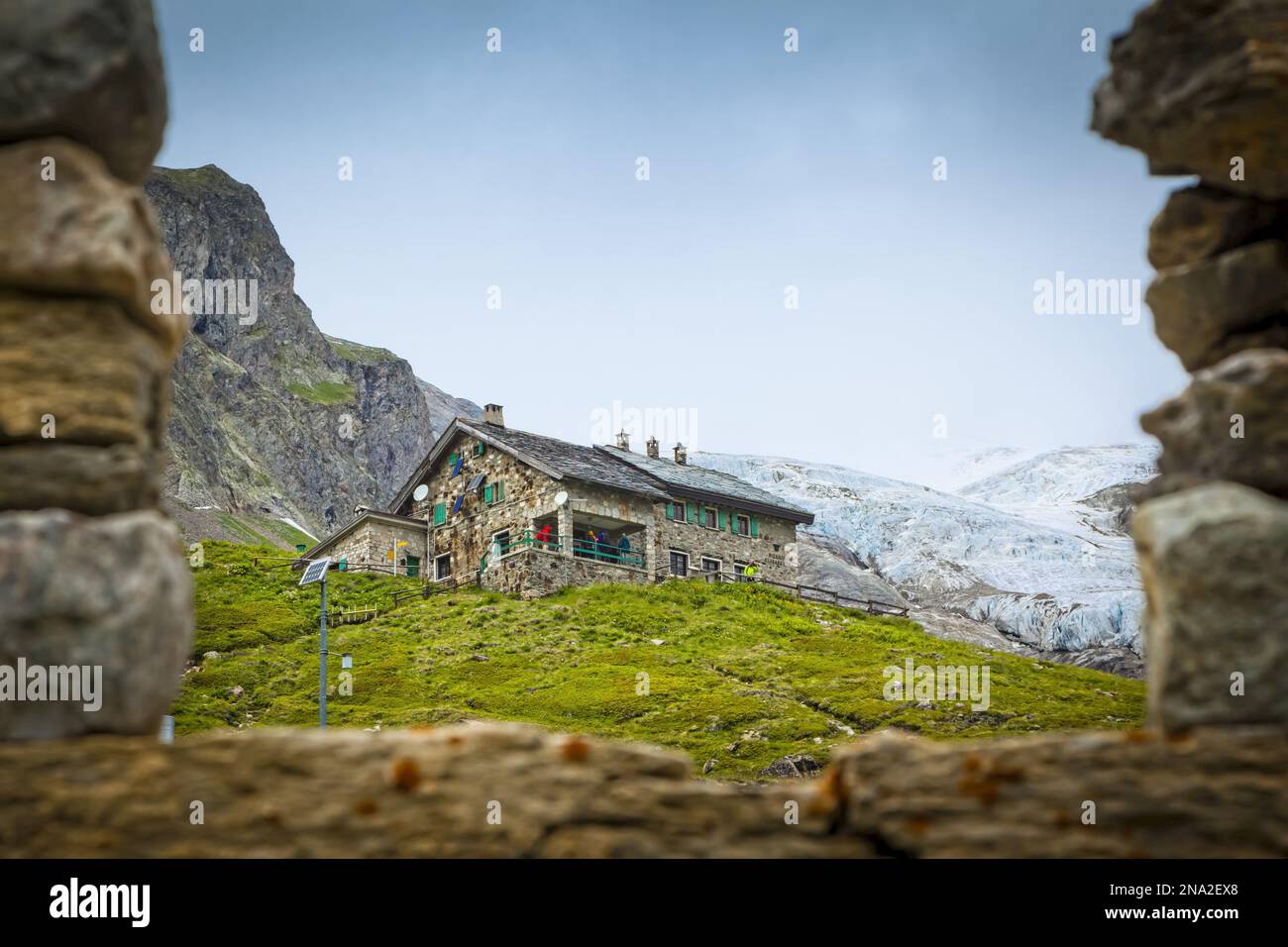 Il rifugio Elisabetta ha visto attraverso le antiche rovine della Val Veni, Alpi; Valle d'Aosta, Italia Foto Stock