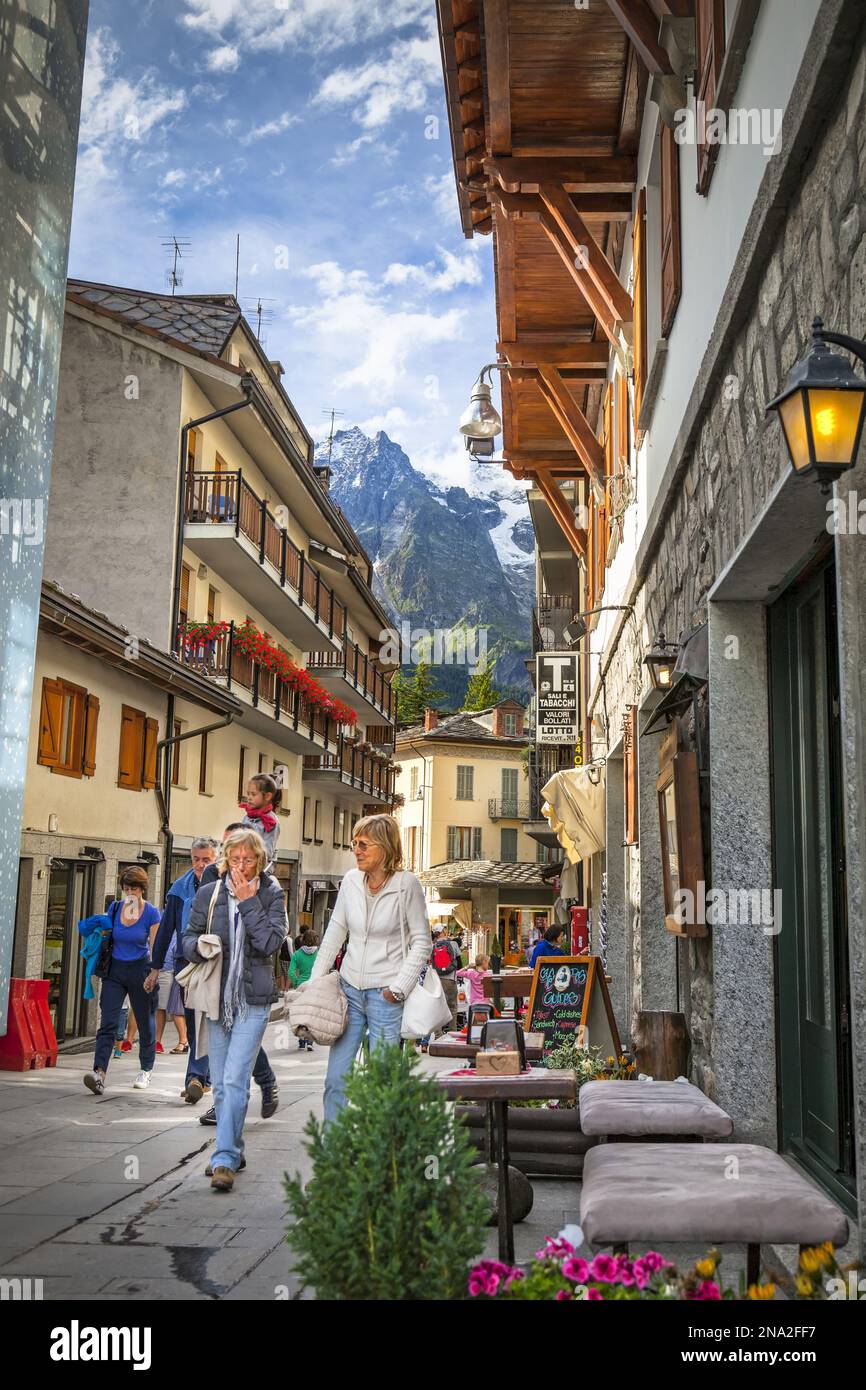 Turisti che passeggiano lungo la trafficata piazza cittadina; Courmayeur, Valle d'Aosta, Italia Foto Stock