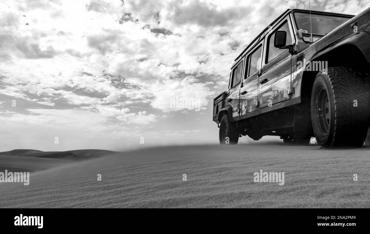 Immagine in bianco e nero di un veicolo ricreativo che corre sulle dune di sabbia, Namib-Naukluft National Park; Sossusvlei, regione di Hardap, Namibia Foto Stock