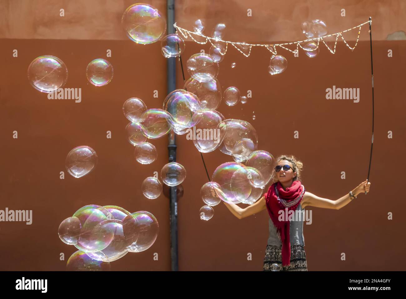 Una giovane donna che crea una performance con grandi bolle; Spagna Foto Stock