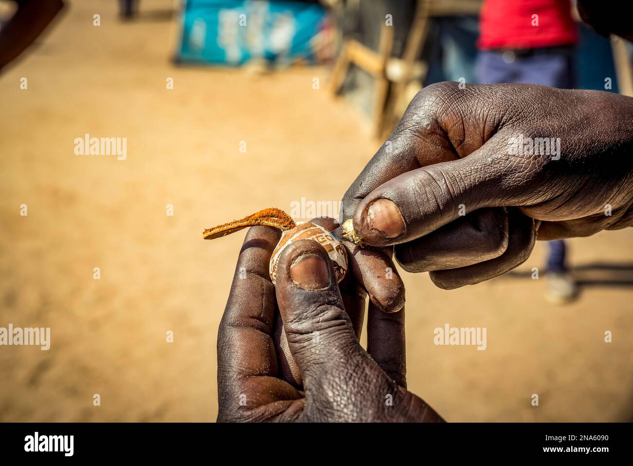 Le mani dell'uomo creano intricatamente un oggetto da vendere al mercato dell'artigianato degli intagliatori di legno di Okahandja Mbangura; Okahandja, regione di Otjozondjupa, Namibia Foto Stock