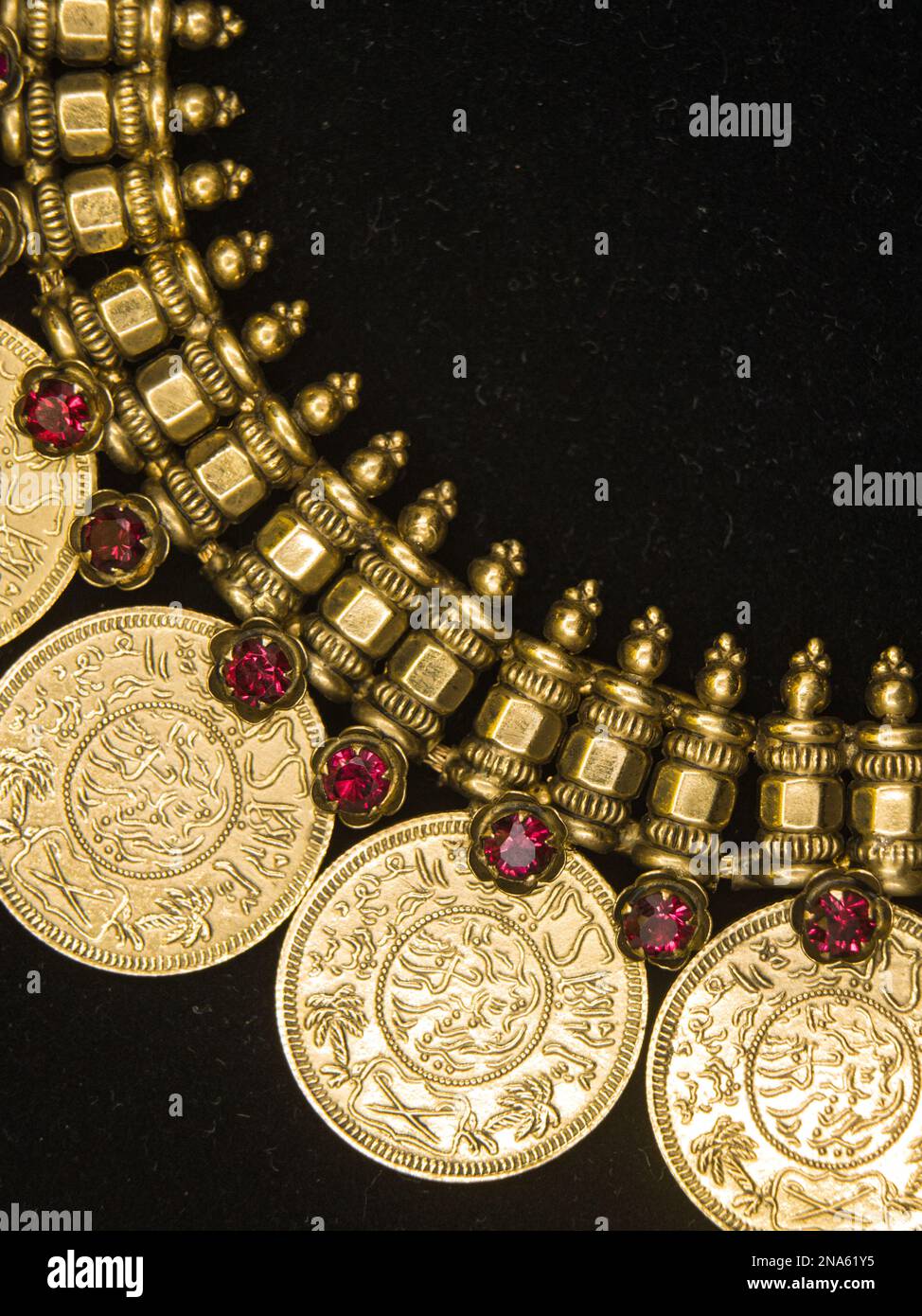 una collana d'oro vintage con un design ornato e sculture dettagliate che è stato utilizzato dai re esposti su uno sfondo nero Foto Stock