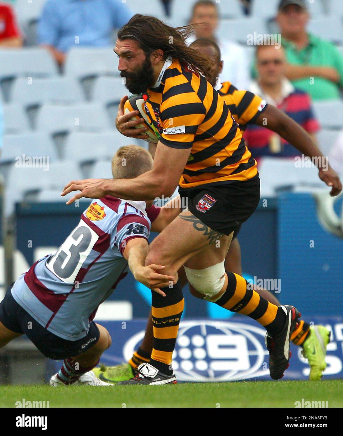 French rugby player Sebastien Chabal, playing for Balmain, right, breaks  through the tackle by Petersham's James Walsh during a club rugby game  against Petersham Saturday, Feb. 25, 2012 in Sydney, Australia. (AP