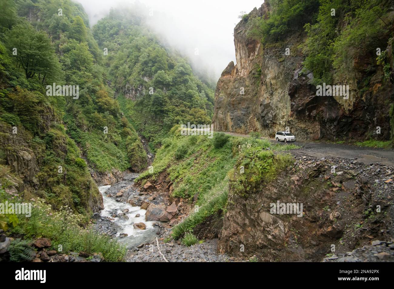 Un SUV bianco guida la pericolosa strada conosciuta come Abano Pass fino a Tusheti, Georgia; Tusheti, Georgia Foto Stock