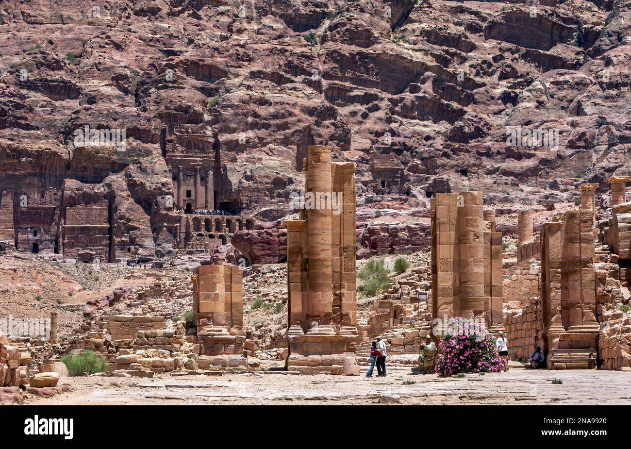 I turisti si trovano accanto alle rovine della porta ad arco nell'antico sito di Petra in Giordania. La porta era una porta monumentale a tre archi. Foto Stock