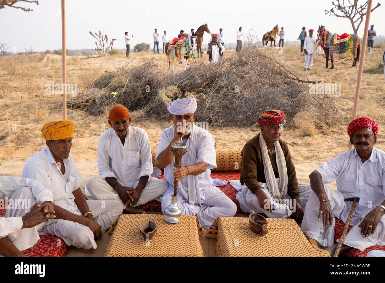Anziani del villaggio che fumano narghilè nel deserto del Thar nel Rajasthan, India; Nagaur, Rajasthan, India Foto Stock