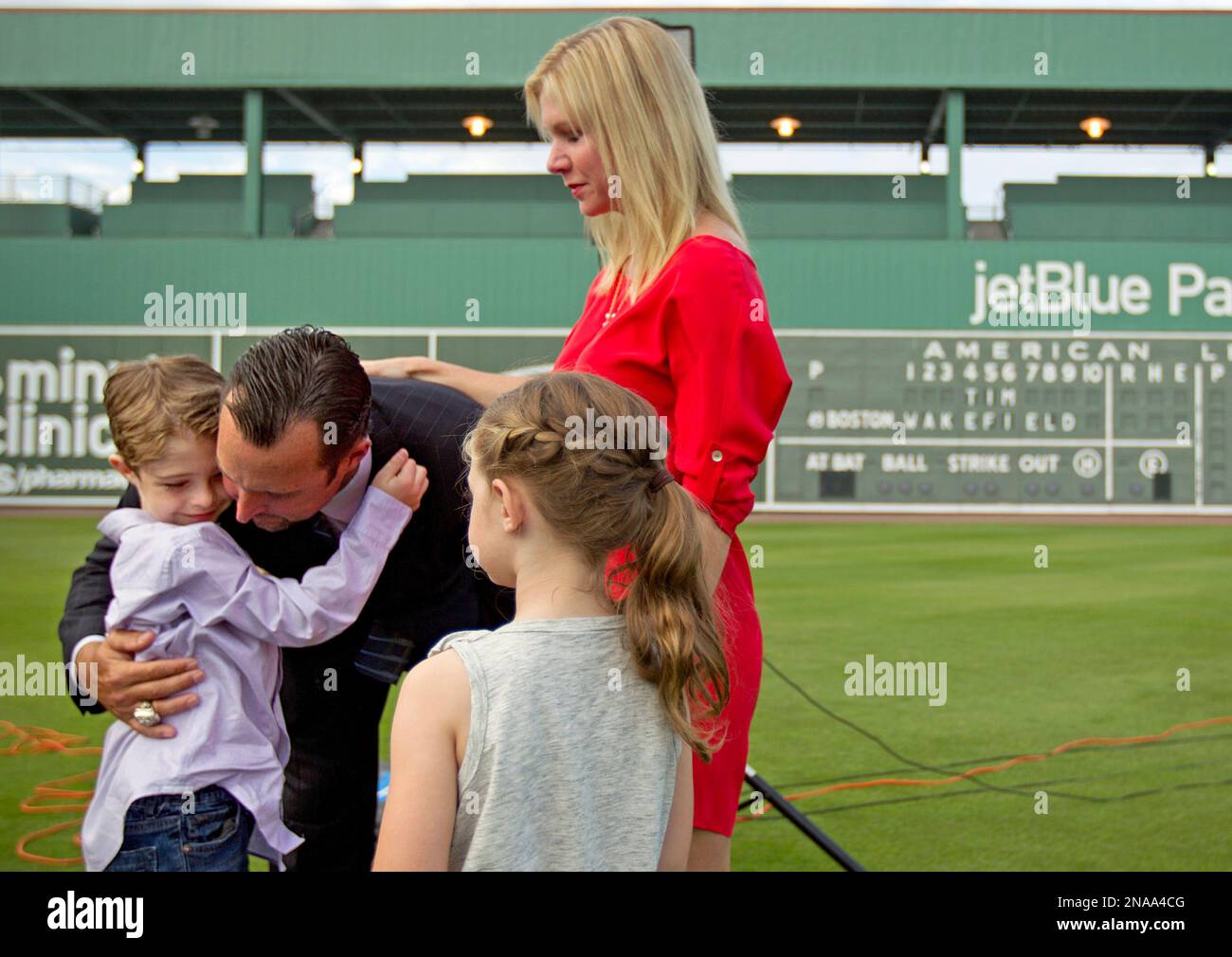 Boston Red Sox pitcher Tim Wakefield, center left, hugs his son, Trevor, 7, as his wife, Stacy, right, and daughter, Brianna, 6, look on after Wakefield announced his retirement from baseball during a news conference, Friday, Feb. 17, 2012, in Fort Myers, Fla. (AP Photo/David Goldman) Foto Stock