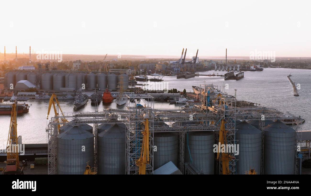 Porto industriale con ascensori e navi. Panorama serale del porto marittimo. Foto Stock
