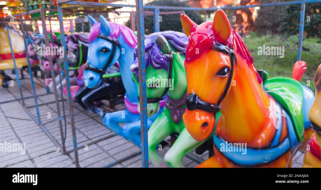 Cavalli fuori di allegro-go-round messo in linea. Formato lungo Foto Stock