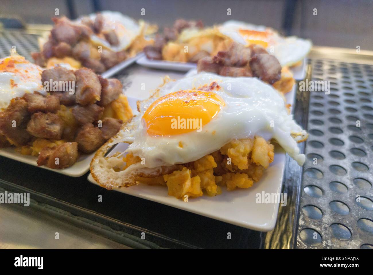 Patate strapazzate con uova fritte o patatas revolconas. Servito al tapas bar desktop Foto Stock