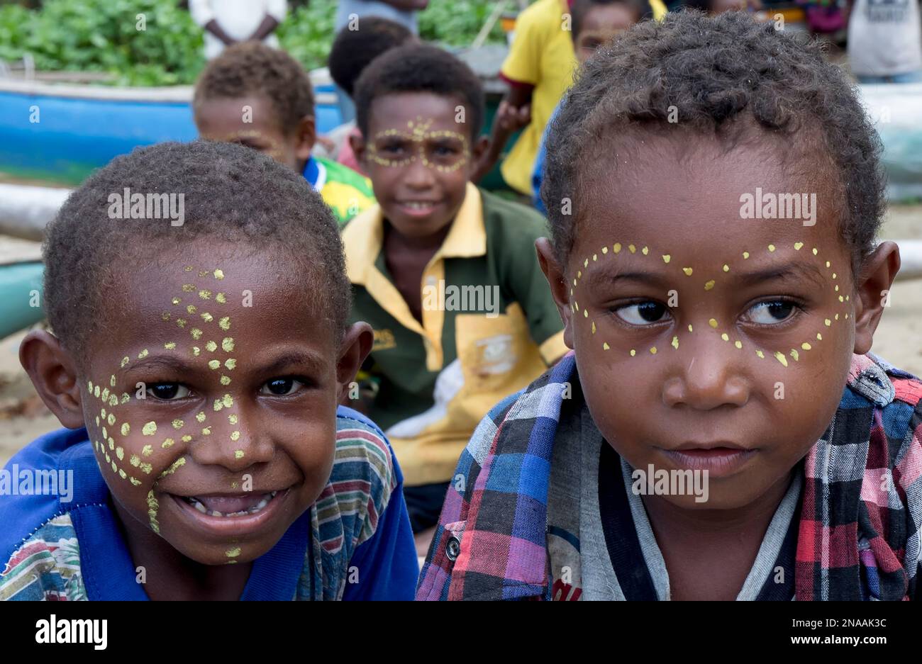 Ragazzi con vernice facciale sulla riva del villaggio di Siboma, isola di Lababia, Golfo di Huon, provincia di Morobe, Papua nuova Guinea Foto Stock