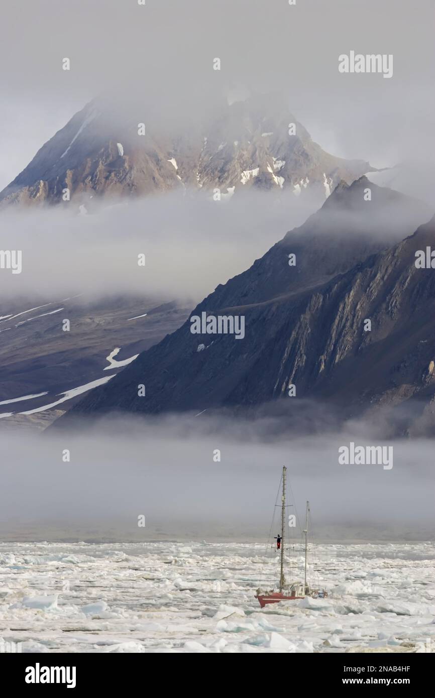 La barca a vela naviga tra pack ICE, Hornsund, Spitsbergen, Svalbard, Norvegia. Foto Stock