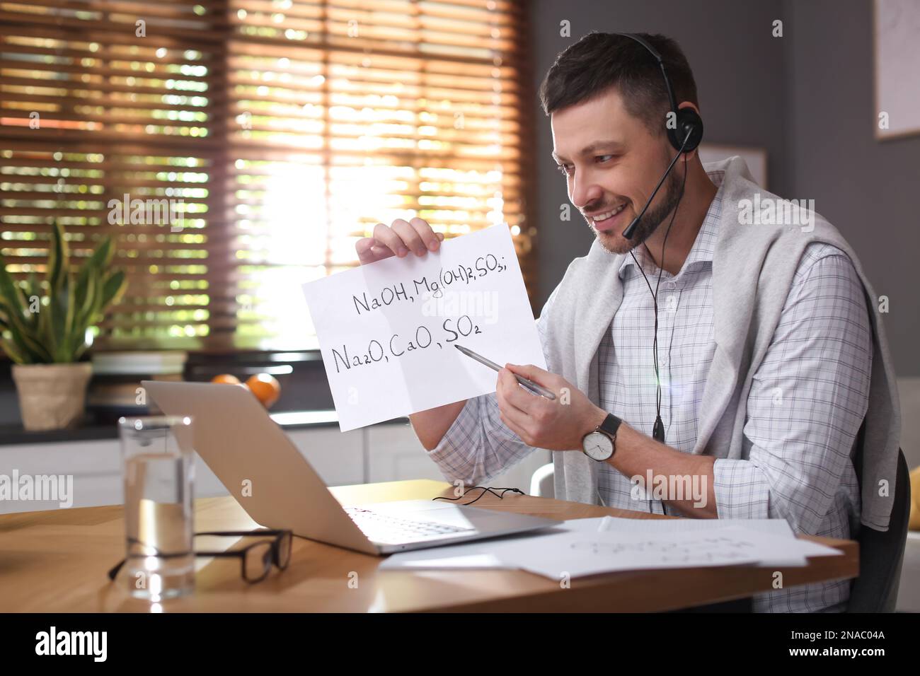 Insegnante che conduce una lezione online a casa durante la quarantena COVID-19 Foto Stock