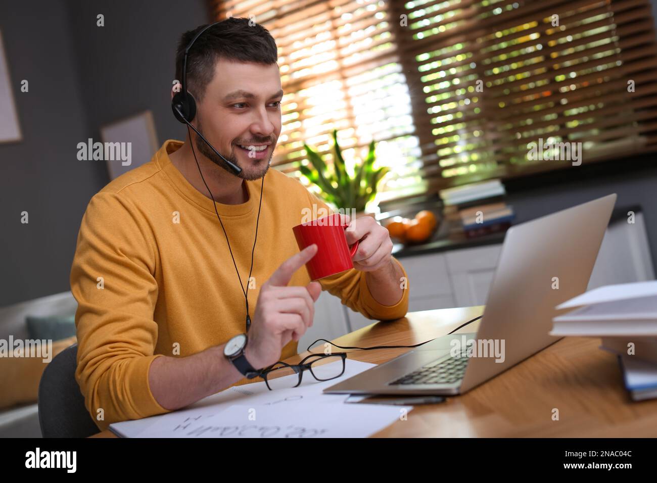Insegnante che conduce una lezione online a casa durante la quarantena COVID-19 Foto Stock