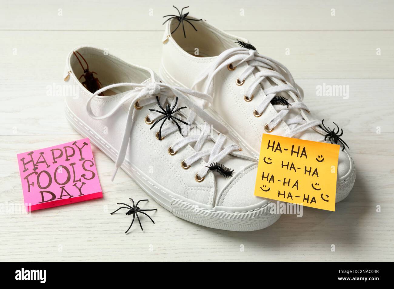 Scarpe con ragni falsi, insetti e Happy Fools' Day nota su tavolo di legno  bianco Foto stock - Alamy