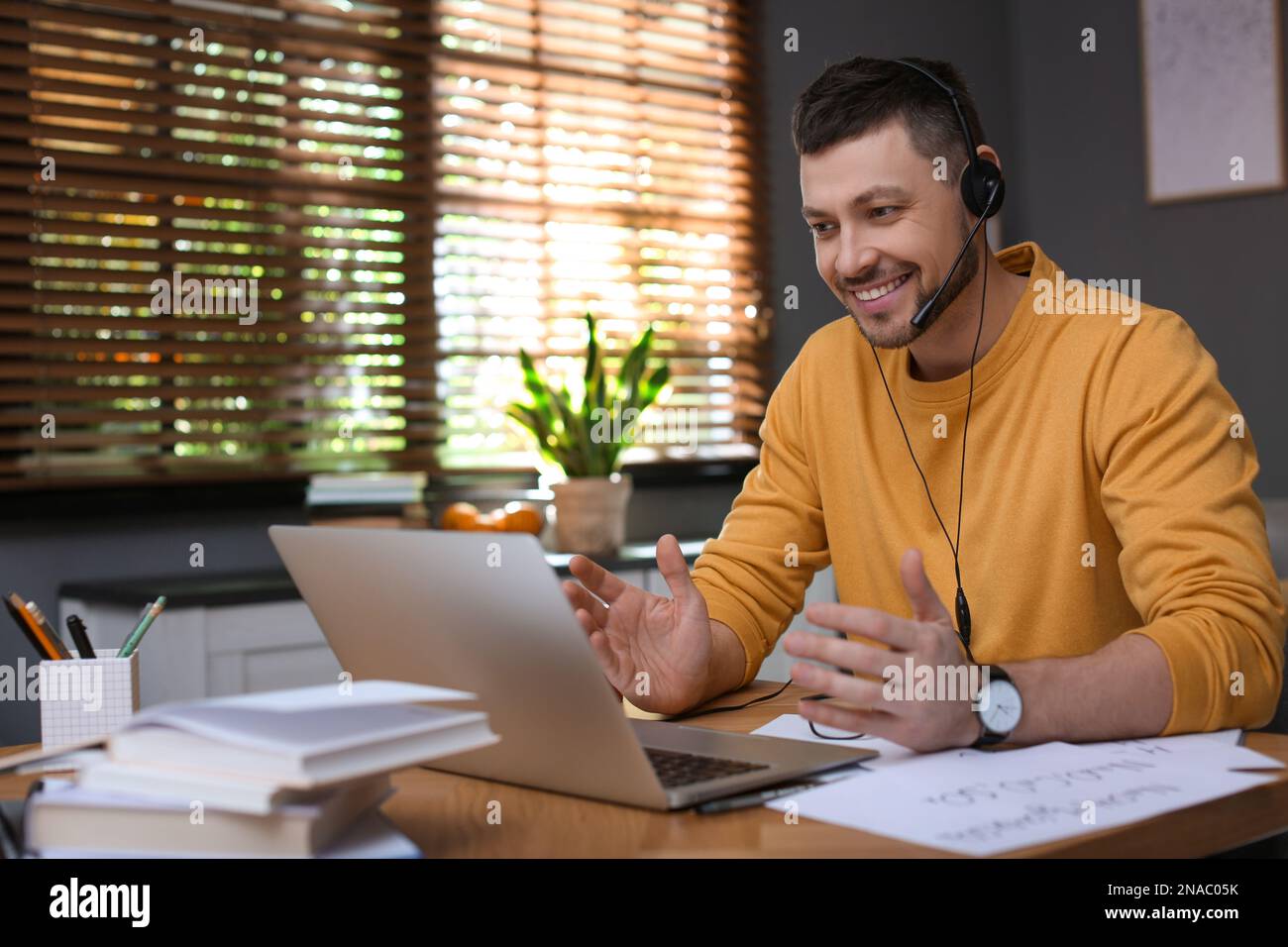 Insegnante che conduce una lezione online a casa durante la quarantena COVID-19 Foto Stock