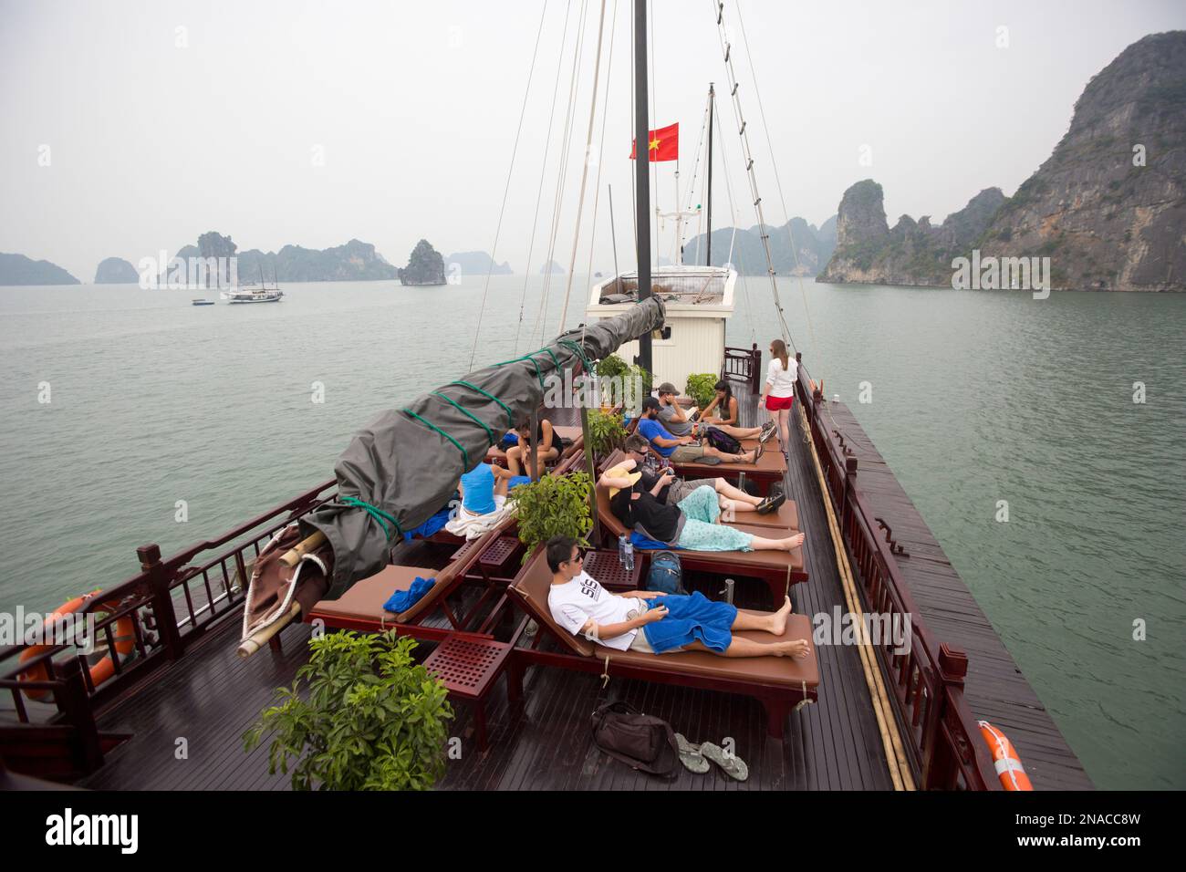 Ospiti su Indocina Junk in Bai Tu Long Bay a Halong Bay, Vietnam MNR Foto Stock