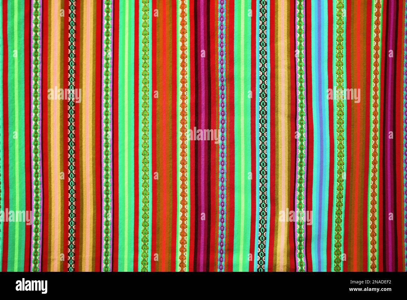 Sorprendente peruviano tessile tradizionale in strisce verticali tonalità rosso e lime Foto Stock