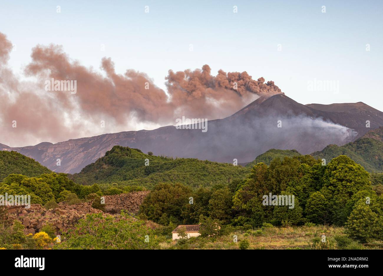 Vaste nuvole di cenere vulcanica e gas tossico che si riversano dal cratere sud-orientale dell'Etna, in Sicilia, a seguito di una piccola eruzione Foto Stock
