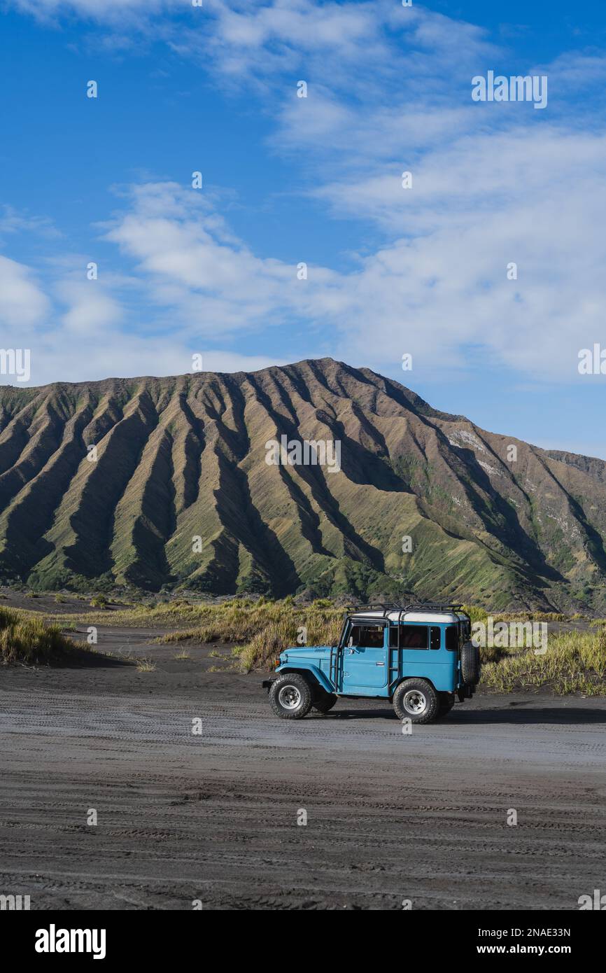 Una Jeep blu 4WD in un paesaggio con colline verdi come sfondo Foto Stock