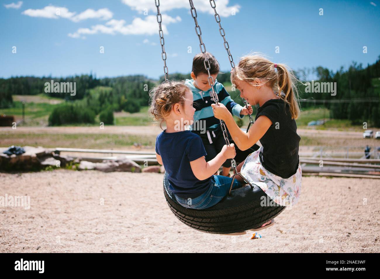 I bambini si stancano sul playset in montagna sotto il sole Foto Stock